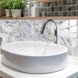 Close-up detail shot of white and gold marble pattern crystal tile stickers in bathroom.