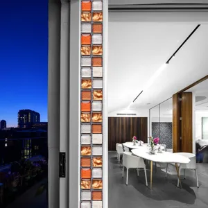Close up view of 3D mosaic tile sticker showing orange and silver square texture in modern interior.