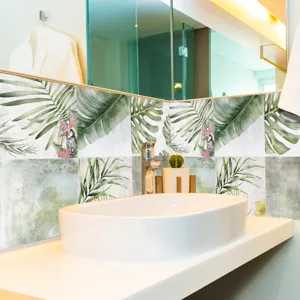 Dettaglio adesivo per piastrelle con foglie tropicali per carta da parati da bagno moderna.