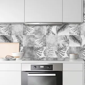 Adesivi per piastrelle con foglie tropicali in bianco e nero per decorazione parete cucina.