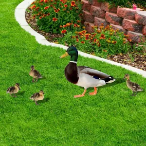 Outdoor garden duck yard art stake detail view showing mallard and cute ducklings on green lawn.