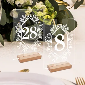 Vista detallada de número de mesa de acrílico transparente con base de madera para bodas.