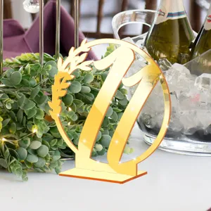 Gold acrylic table number 11 sign with mirror finish and leaf wreath for wedding party decor.
