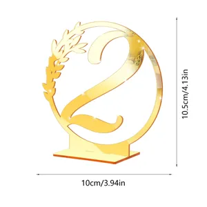 Gold mirror acrylic table number 2 detail view with elegant wreath design and stable base.