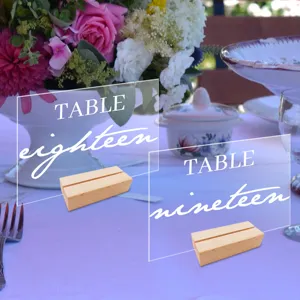 Clear acrylic wedding table numbers with wooden bases for elegant event table decor display.