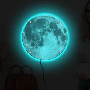 Detail view of the glowing 3D moon wall lamp with bright cyan ambient light in a room.