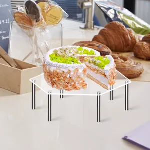 Detaillierte Nahaufnahme des klaren Acryl-Display-Ständers mit Metallbeinen für Kuchen.