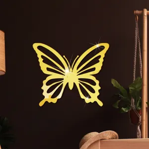 Gedetailleerd overzicht van gouden acryl spiegel vlinder muursticker in gezellige kamer.