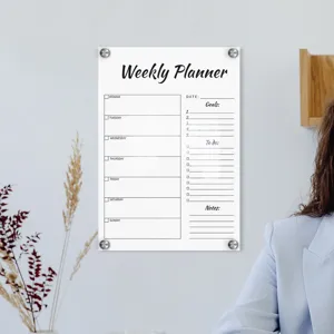 Clear acrylic weekly planner mounted on wall with sleek metal standoffs for modern office.