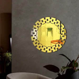 Close-up view of the golden geometric wall mirror reflecting the warm modern interior room.
