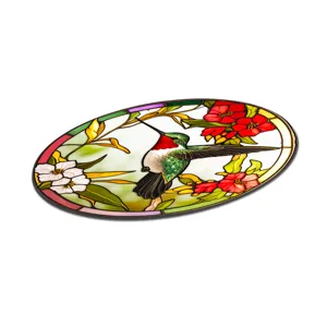Detailopname van de kleurrijke glas-in-lood kolibrie wanddecoratie met levendige rode bloemen.