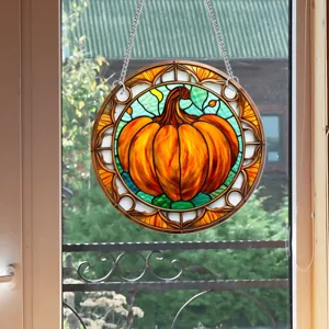 Dettaglio decorazione sospesa zucca in vetro colorato, acchiappasole con catena metallica.