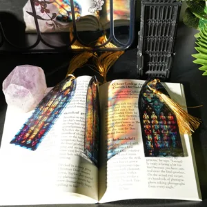 Close-up detail of translucent stained glass acrylic bookmark with elegant golden tassel decor.