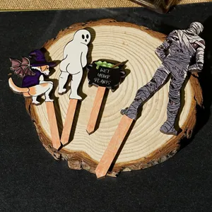 Detail shot of funny Halloween plant wooden stakes, featuring cute ghost and dog designs.