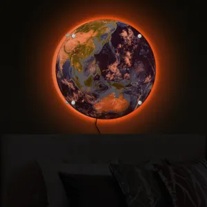 Detailed view of glowing Earth wall lamp with warm LED backlighting mounted above a cozy bed.