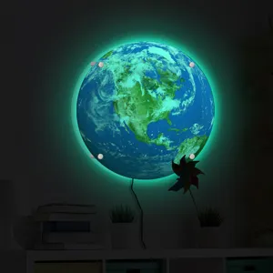 Detailed view of the glowing earth wall lamp showing vibrant green backlighting in a dark room.
