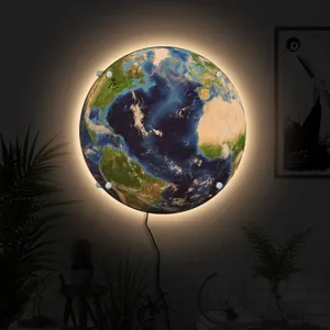 Detailed view of the creative LED earth wall lamp hanging on a brick wall with warm glow.