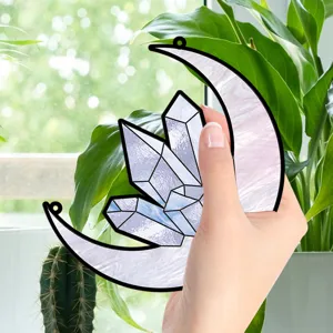 Close-up detail shot of the moon crystal suncatcher hanging against a bright window scene.