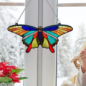 Detailed view of a colorful stained acrylic butterfly hanging pendant on a window.