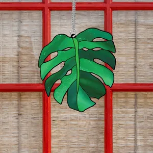 Green monstera leaf acrylic hanging decor detail, vibrant botanical window ornament piece.