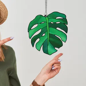 Green monstera leaf acrylic hanging pendant for stylish home wall and window decoration.