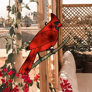 Detailed shot of a vibrant red cardinal bird acrylic hanging ornament displayed outdoors.