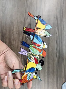 Colorful acrylic stained glass bird hanging ornament detail view, window suncatcher decor.