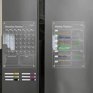 Close-up detail of clear acrylic magnetic calendar boards attached to refrigerator surface.