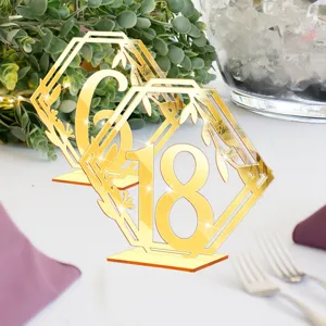 Numéros de table de mariage en acrylique doré avec design géométrique et support élégant.
