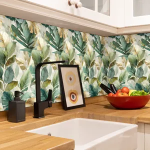 Dettaglio adesivo per piastrelle cucina con design a foglie tropicali per paraschizzi.
