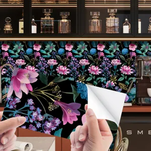 Dettaglio carta da parati adesiva floreale con vivaci fiori rosa e blu su sfondo nero.