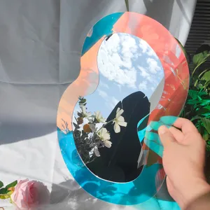 Miroir mural en acrylique iridescent, decor holographique irregulier pour interieur moderne.