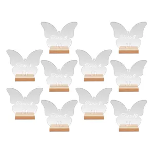 Clear acrylic butterfly table numbers with wooden base set for wedding event party display details.