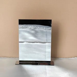 Detalle de soporte de escritorio de acrílico, portatarjetas transparente con base metálica.