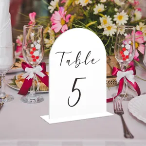 Acrylic arch table number sign detail view, modern wedding reception decor centerpiece setup.