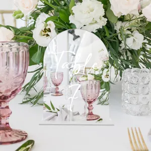 Clear acrylic arch table number sign with white script text for wedding party decor.