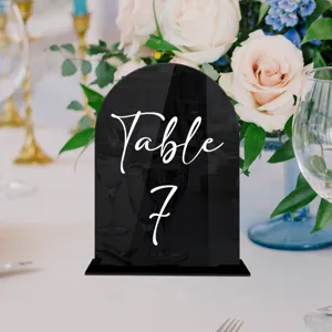 Black acrylic table number sign detail close-up, wedding table decor with elegant white text.