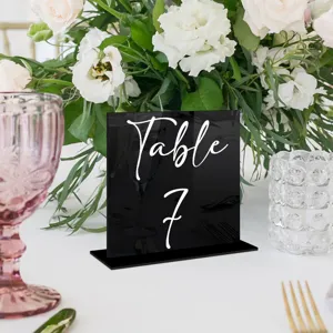 Vista detallada del número de mesa de boda de acrílico negro con elegante escritura blanca.