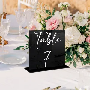 Vista detallada del cartel de mesa de acrílico negro con elegante texto blanco para bodas.