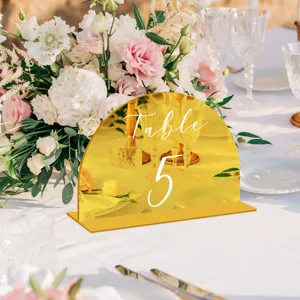 Detalle de cartel de número de mesa de acrílico dorado para boda, decoración elegante.