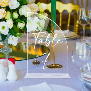 Señal de número de mesa de boda de acrílico con base de metal dorado en detalle.
