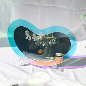 Vue détaillée d'un miroir décoratif en acrylique iridescent irrégulier au bord coloré.