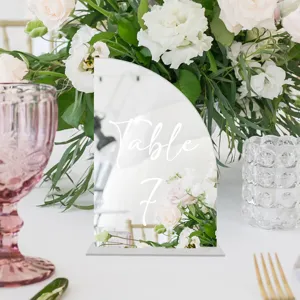 Vista de detalle de letrero de mesa de acrílico, tarjeta de lugar de boda DIY con flores.