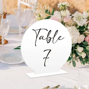 Detalle de cartel de numero de mesa de acrilico blanco, decoracion de recepcion de boda.