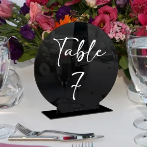 Vista detallada del número de mesa de acrílico negro, con bordes limpios y texto blanco elegante.