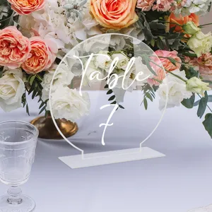 Detalle de letrero de mesa de acrílico transparente con número manuscrito para boda y fiesta.