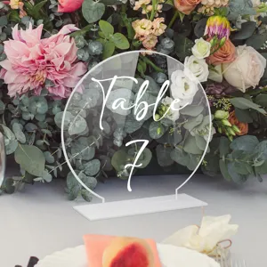 Cartel de número de mesa en acrílico transparente con base blanca, elegante detalle de boda.