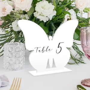 Vista detallada del número de mesa de mariposa de acrílico blanco para decoración de bodas.