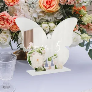 Vista detallada del número de mesa de mariposa de acrílico con fondo floral para boda.