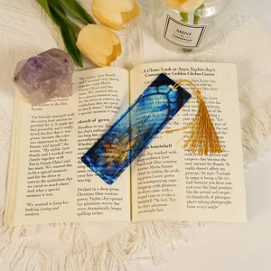 Transparent acrylic bookmark featuring dragon design with gold tassel, ideal for reading lovers.